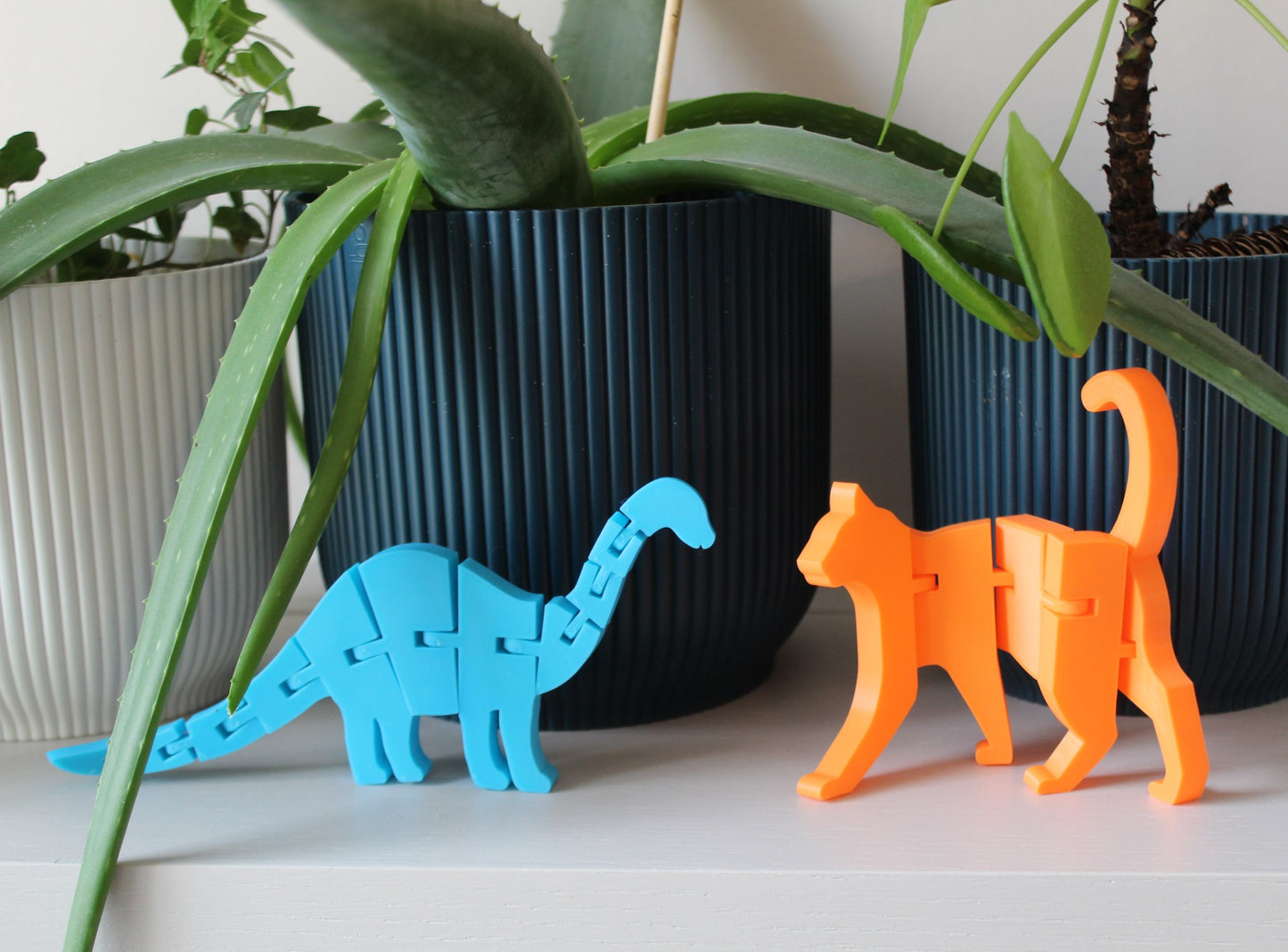 An articulated Dinosaur and a Cat on a shelf