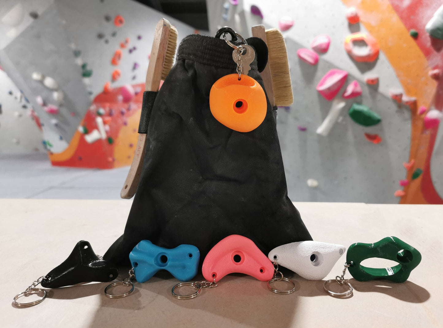 Climbing Holds keychains next to a Chalk Bag