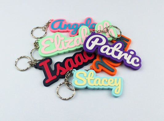 3D Printed Colourful keychains with personalized names on a light gray background