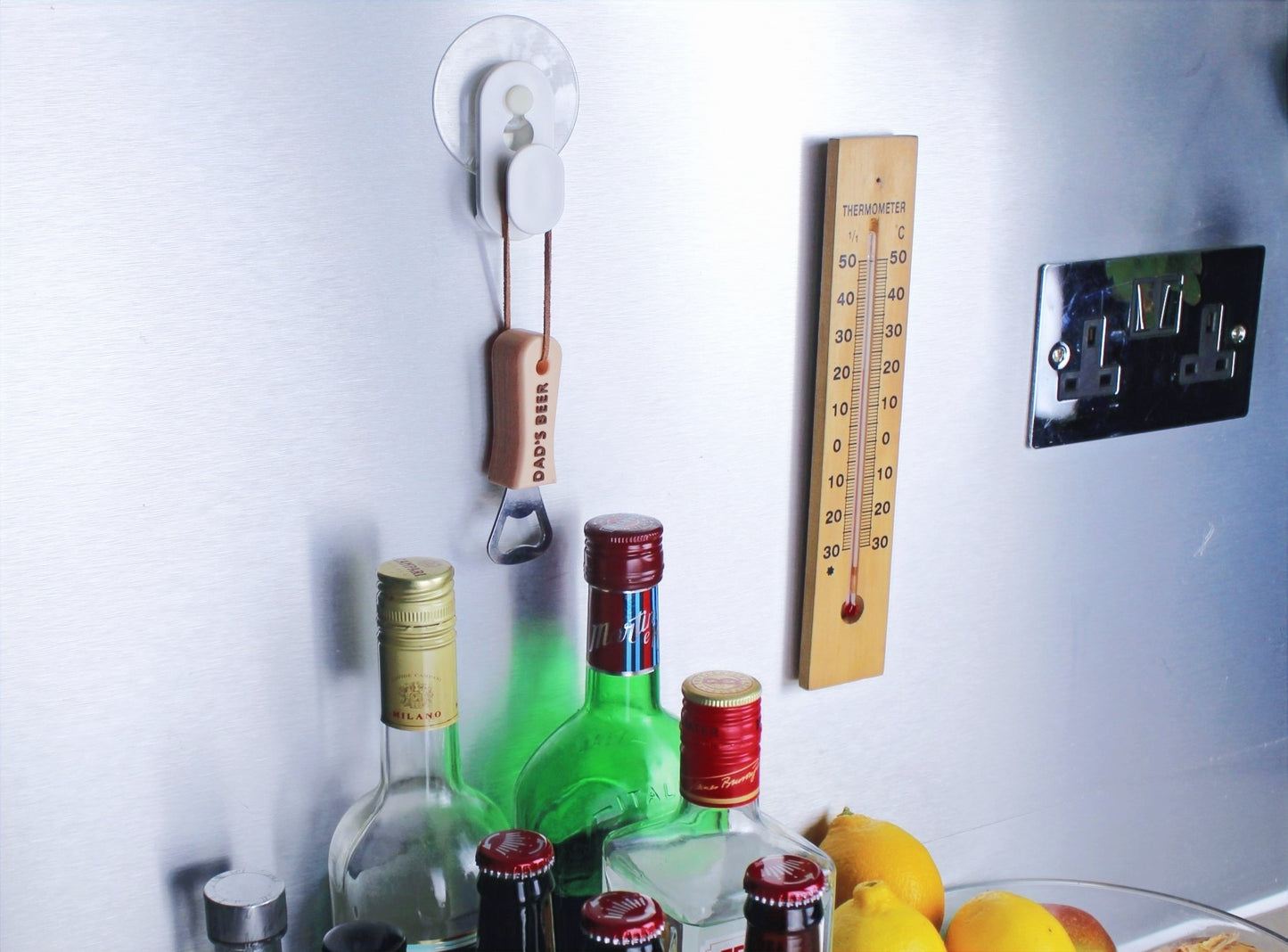 Beige Personalised Bottle Opener with Brown inscription Hanging on a hook, above liquor bottles
