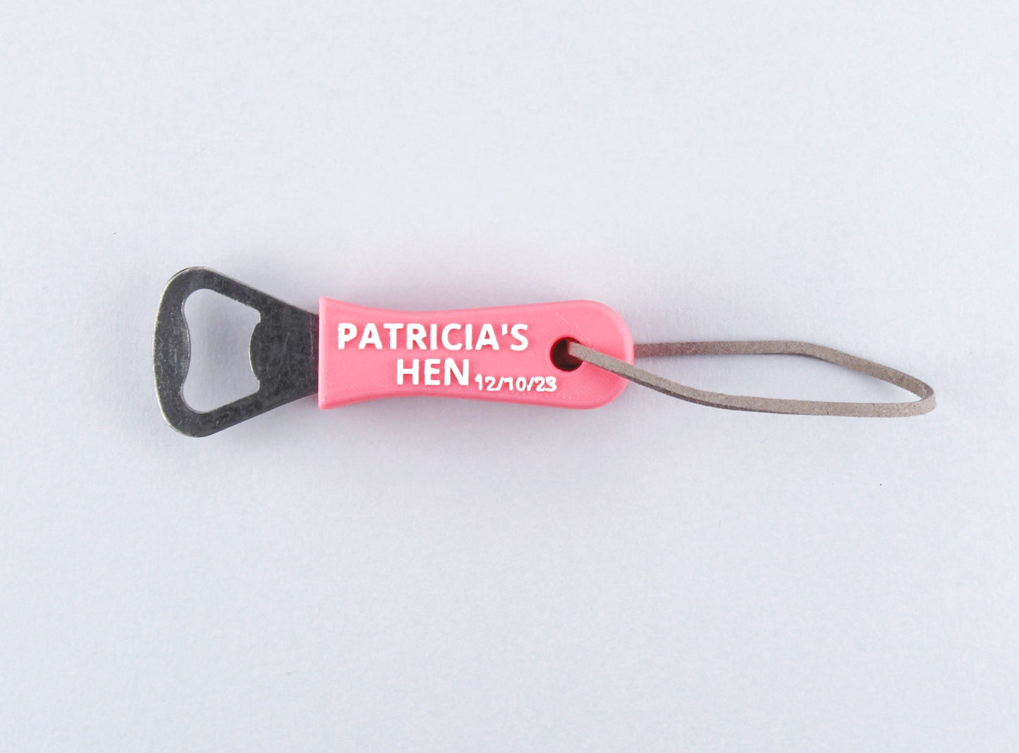 Pink Personalised Bottle Opener with the inscription Patricia's Hen 12/10/23 in white, and a Leather Strap