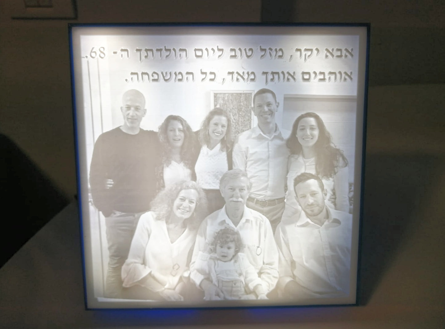 A lit Lithophane lamp, showing a black and white photo of a family with a caption