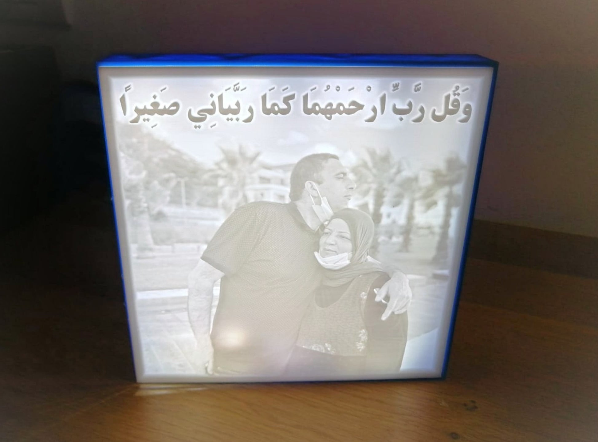 A lit Lithophane lamp, showing a black and white photo of a couple with a caption