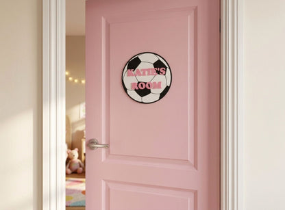 Pink door with a room sign featuring a soccer ball design and the text 'Katie's Room'.