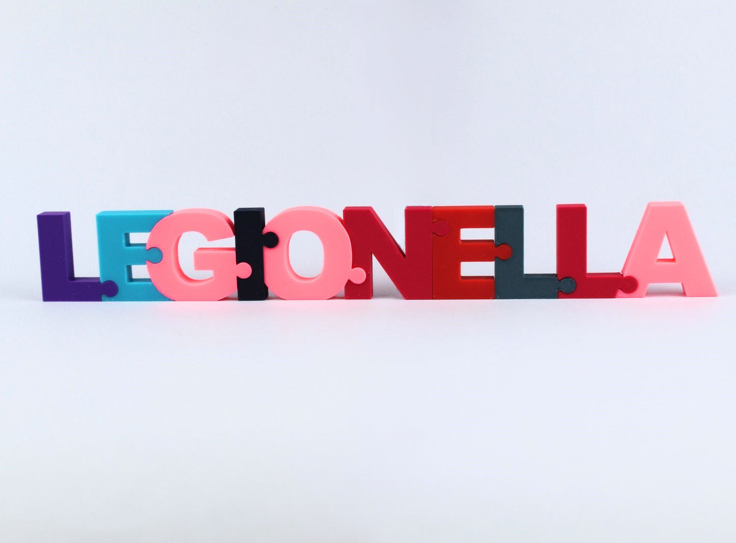 3D Printed Personalised Name Puzzle. Colourful 3D letters spelling 'LEGIONELLA' on a light grey background