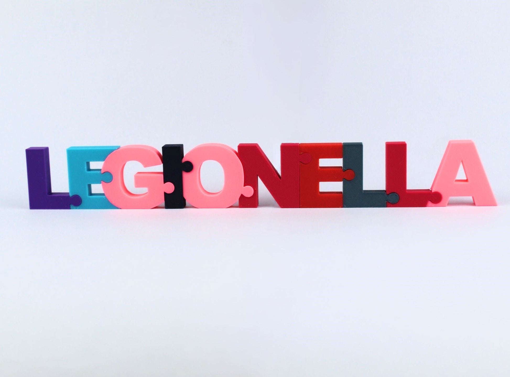 3D Printed Personalised Name Puzzle. Colourful 3D letters spelling 'LEGIONELLA' on a light grey background