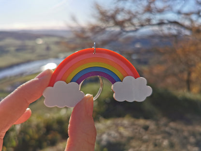 Hand holding 3D printed rainbow keychain