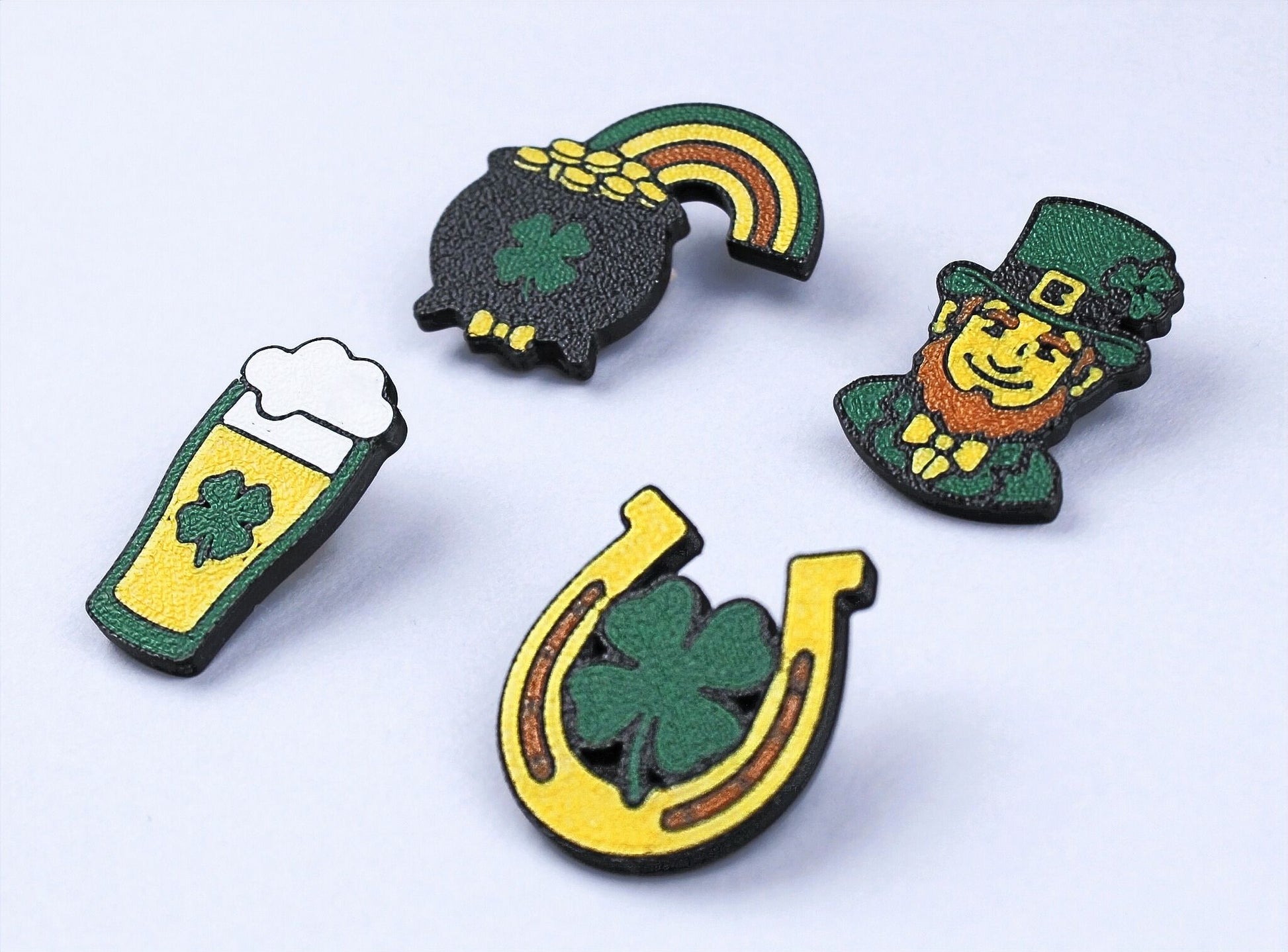 Four St. Patrick's Day-themed pins on a light grey background