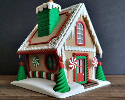 Decorative gingerbread house with candy-themed details on a wooden surface.