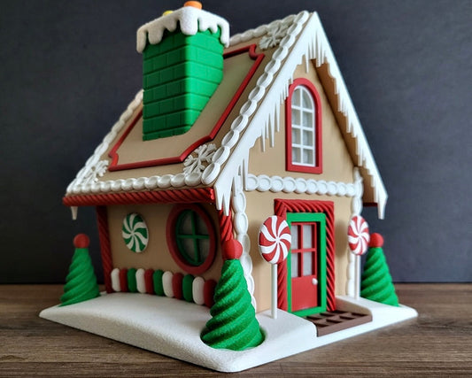 Decorative gingerbread house with candy-themed details on a wooden surface.