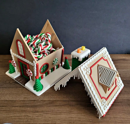Decorative gingerbread house with candy decorations on a wooden surface.