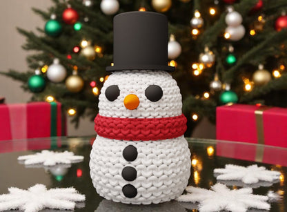 Knitted Effect Snowman Decoration with a black top hat and red scarf in front of a Christmas tree.
