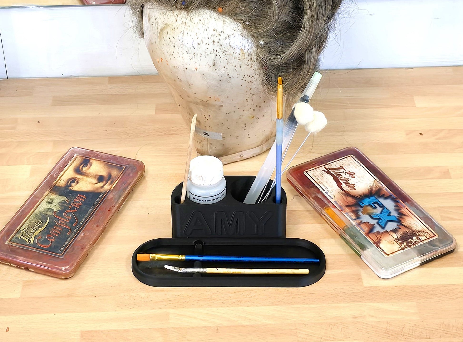 Mannequin head with various makeup tools and a 3D Printed Personalised Makeup Brush Holder
with some brushes on it, on a wooden surface