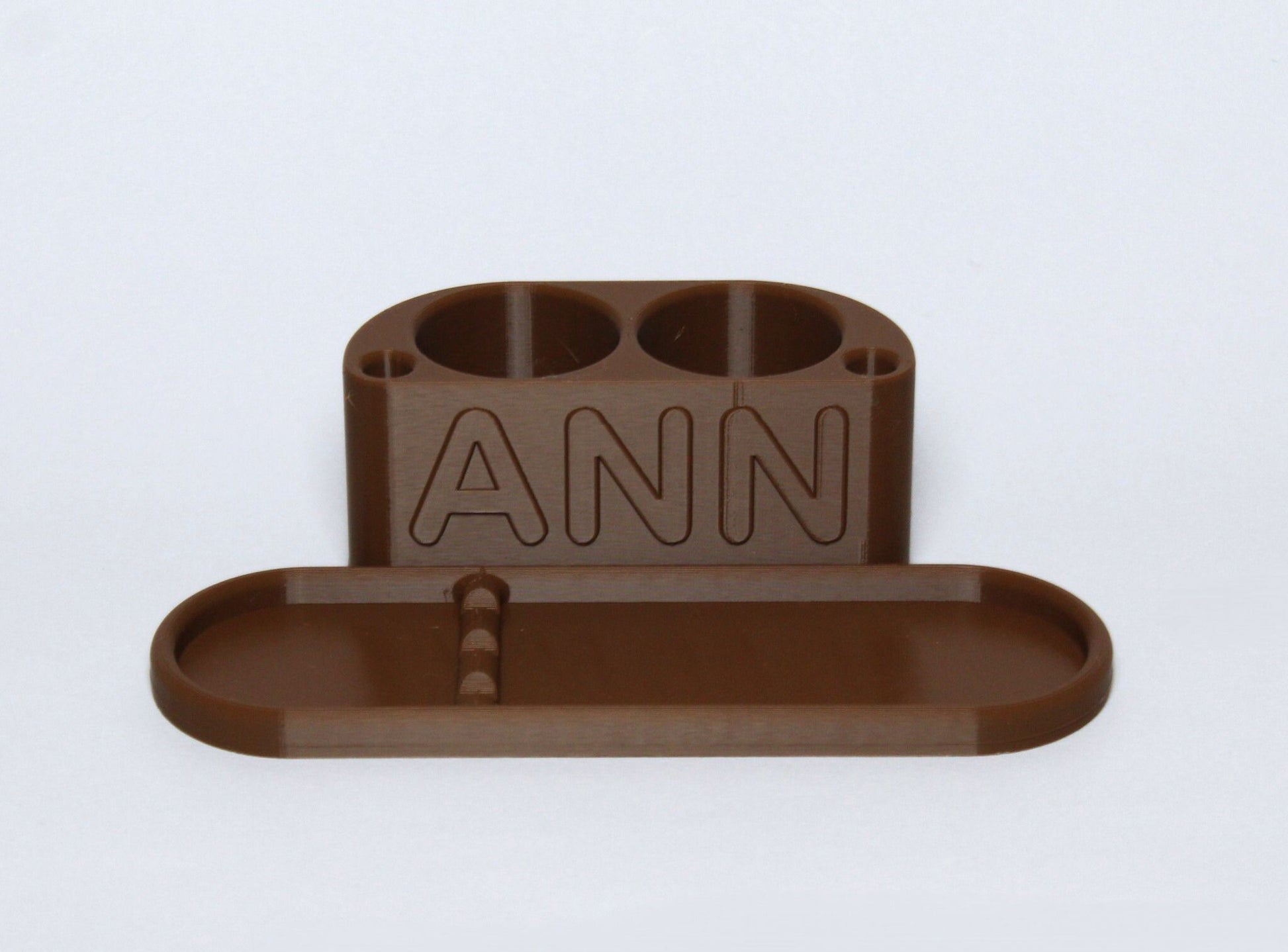 3D printed Brown Personalised Makeup Brush Holder with 'ANN' branding on a light gray background