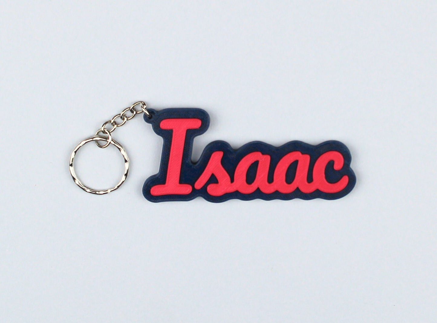 3D Printed Keychain with 'Isaac' in red letters on a blue background