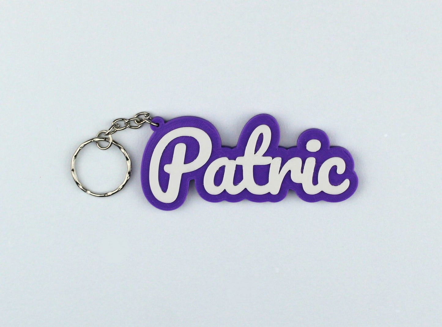 3D Printed Purple keychain with 'Patric' text on a light gray background