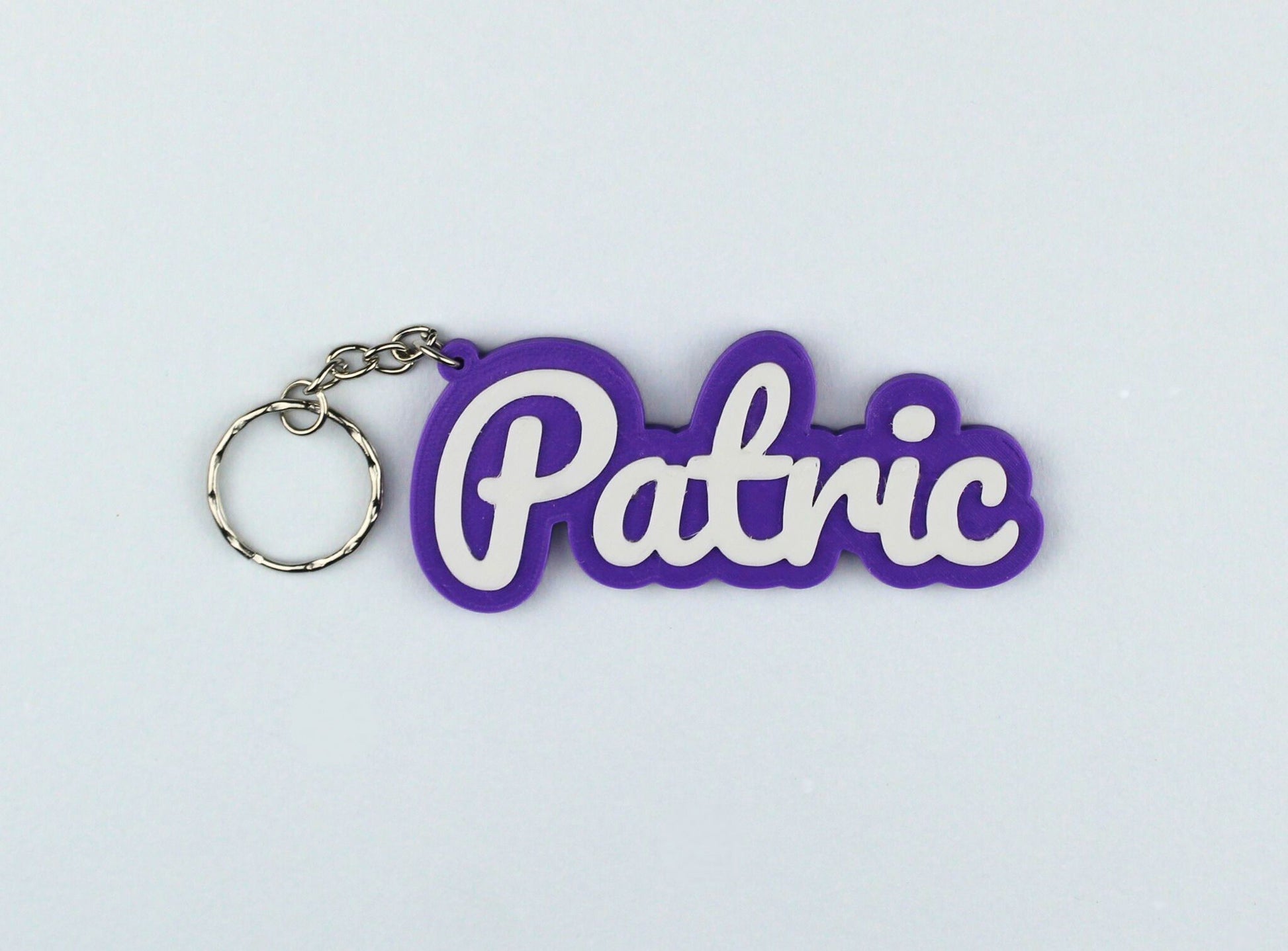 3D Printed Purple keychain with 'Patric' text on a light gray background