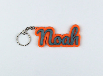 3D Printed Keychain with 'Noah' in orange and gray on a light gray background