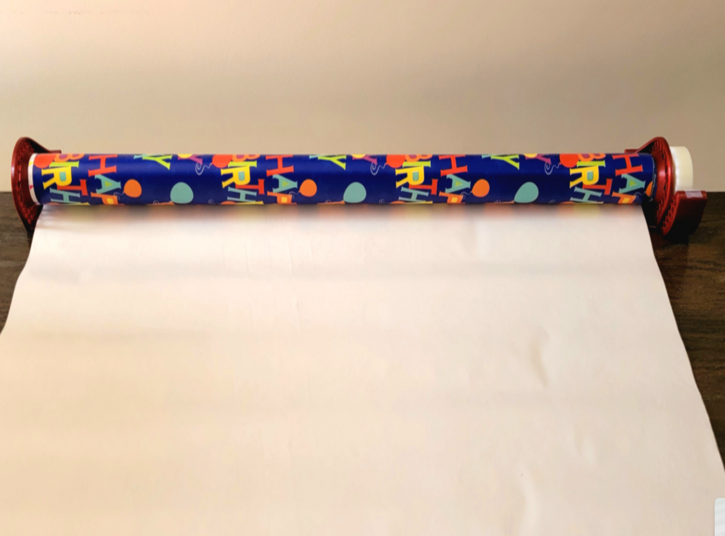 Red 3D-printed Tabletop Gift Wrap clip on a wooden surface with colorful packaging paper