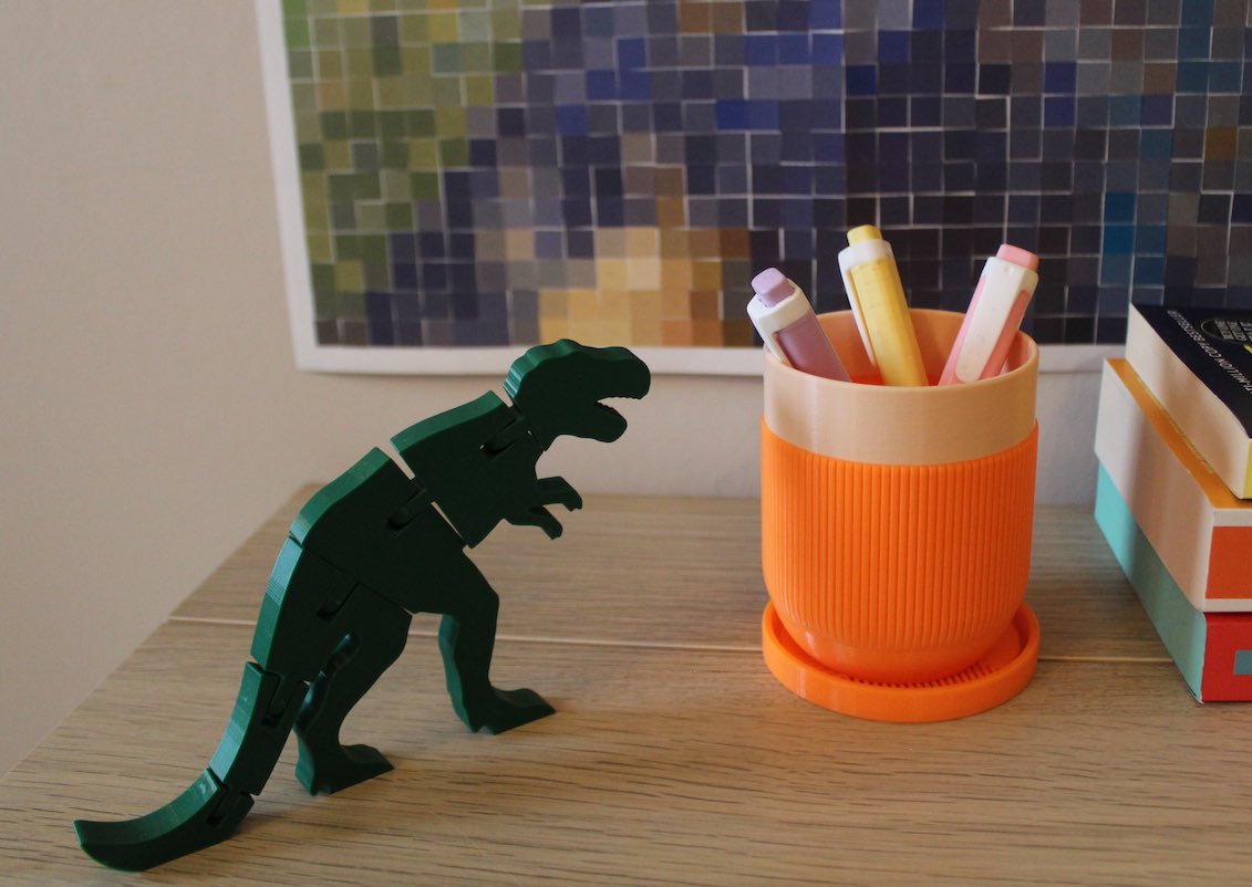 Articulated Trex next to a Pen Holder on a desk