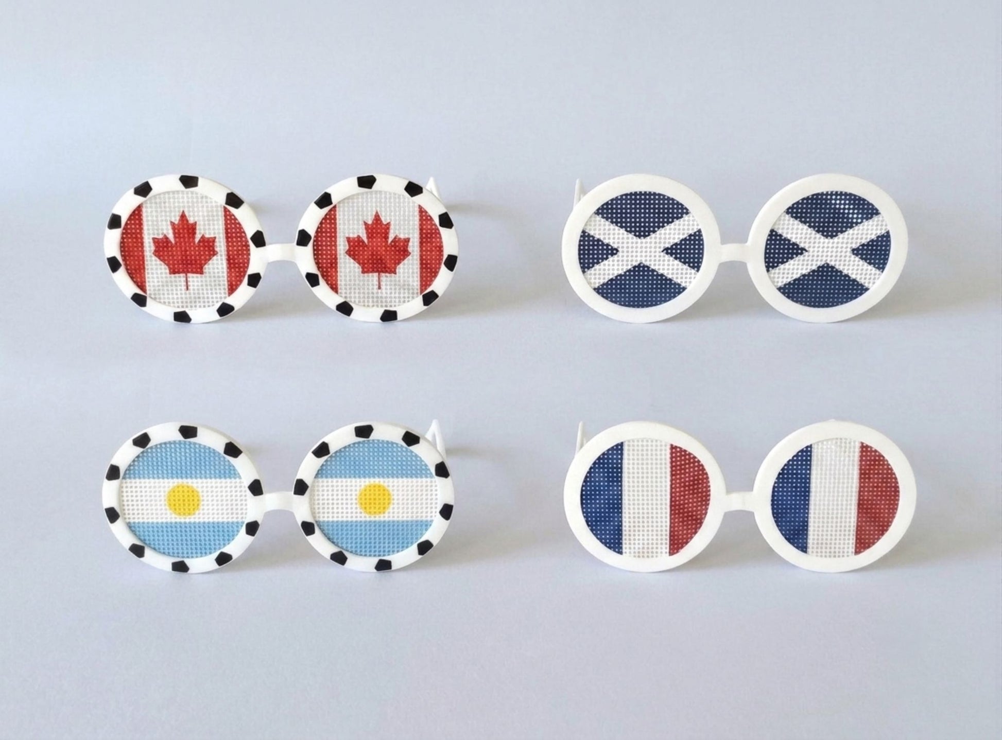 Set of novelty sunglasses with different country flags on a light gray background