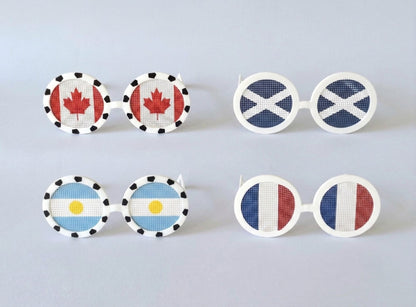 Set of novelty sunglasses with different country flags on a light gray background