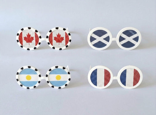 Set of novelty sunglasses with different country flags on a light gray background