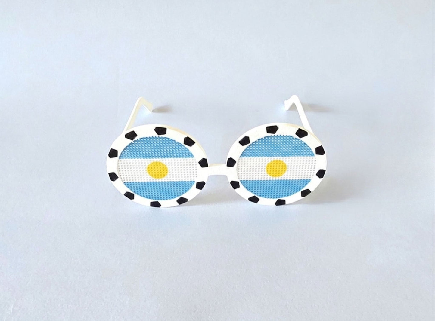 Sunglasses with the Argentine flag on a light gray background