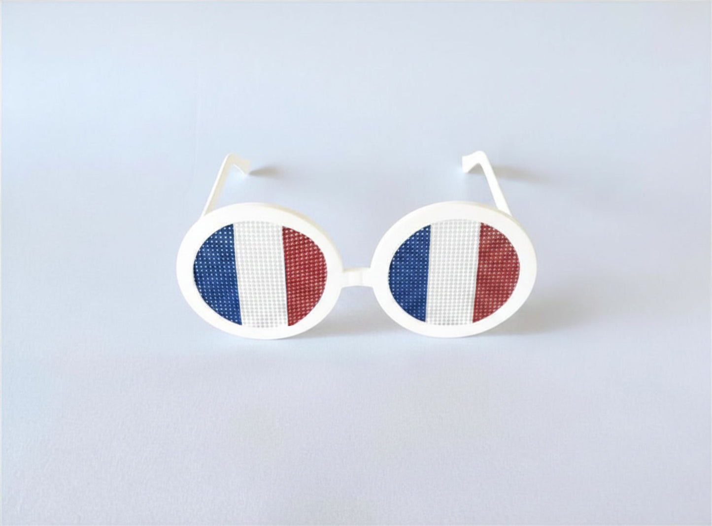 Sunglasses with the French flag on a light gray background