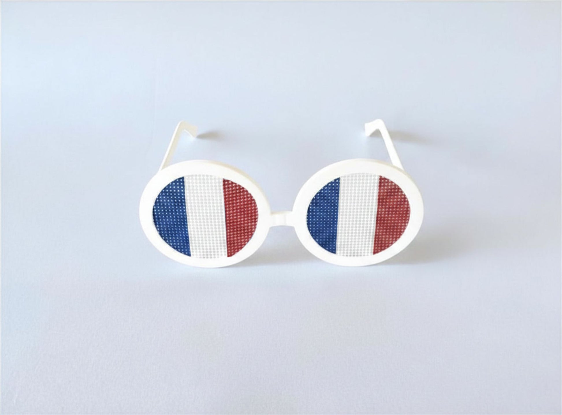 Sunglasses with the French flag on a light gray background
