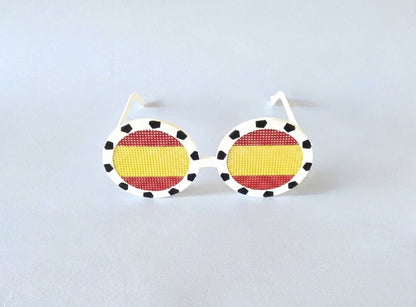 Sunglasses with a Spanish flag design on a light gray background