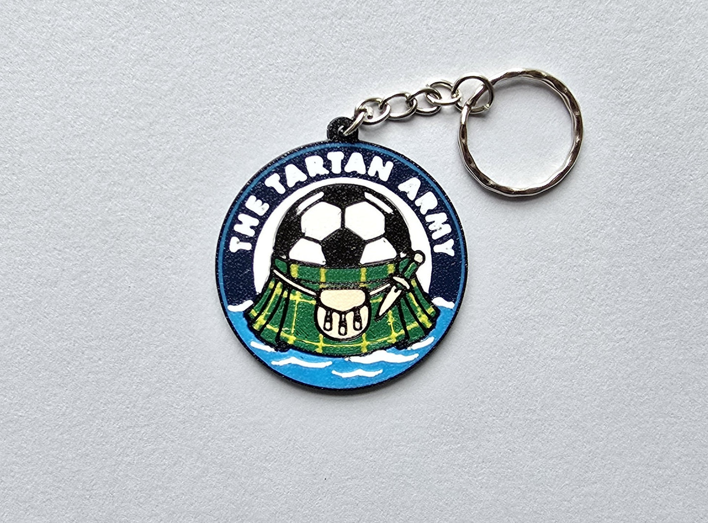 Keychain with a tartan design and soccer ball on a gray background