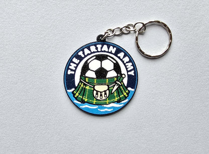 Keychain with a tartan design and soccer ball on a gray background