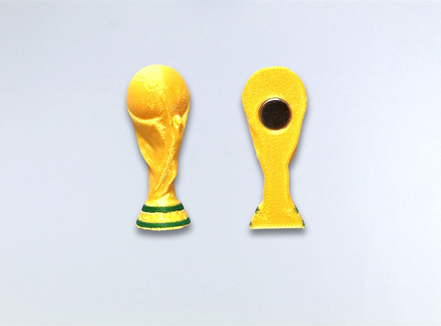 Two yellow World Cup trophies on a light gray background